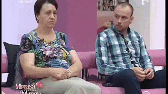 a man and a woman are sitting on a couch talking to each other .
