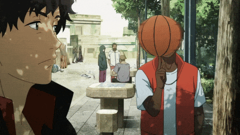 a man with a basketball on his head stands in a park with other people