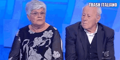 a man and a woman are sitting next to each other with trash italiano written on the screen