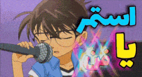 a boy with glasses is singing into a microphone with arabic writing behind him