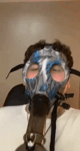 a man is wearing a gas mask and smoking a pipe .