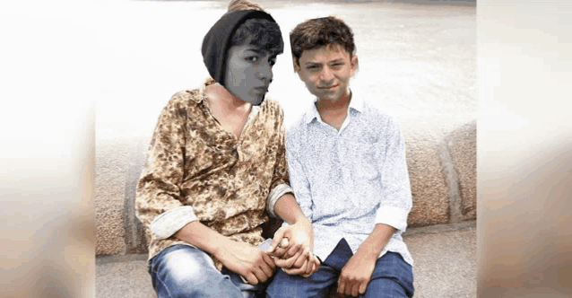 two young men sitting next to each other with one wearing a mask