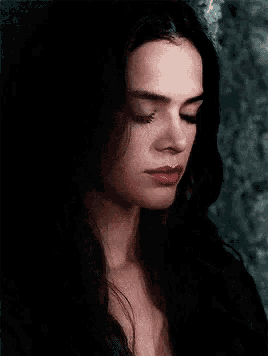 a close up of a woman 's face with her eyes closed .