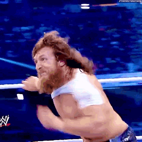 a man with a beard is in a wrestling ring with a w logo