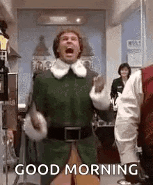 a man in an elf costume is screaming and saying `` good morning '' in a kitchen .