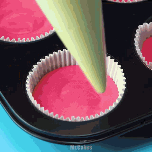 cupcakes are being poured into a pan with the words mr.cakes written on the bottom