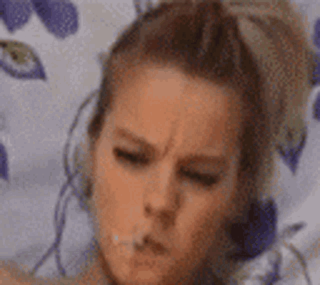 a close up of a woman laying on a bed with her eyes closed and her mouth open .