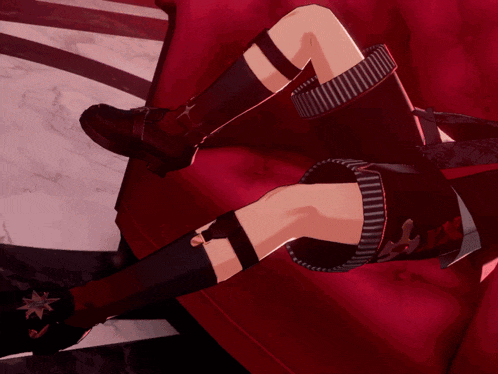 a person is laying on a red couch with their feet crossed