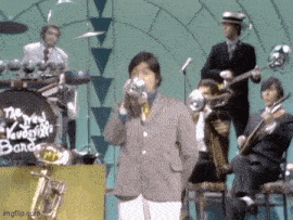 a man playing a trumpet in front of a band that says the new york voodoo band