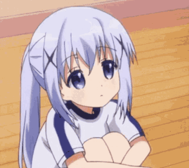 a girl with blue hair is sitting on a wooden floor