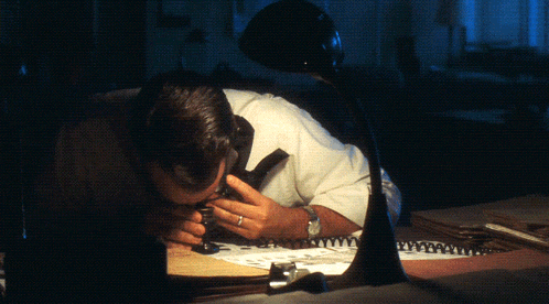 a man looking through a magnifying glass at something