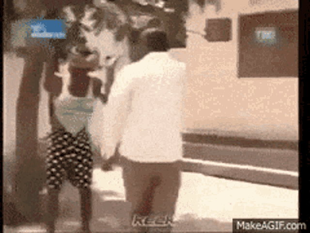 a man and a woman are holding hands and walking down a street
