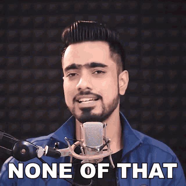 a man singing into a microphone with the words " none of that " above him