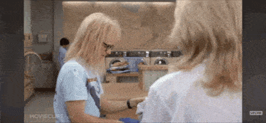 two women are standing in a laundromat with the words movieclips.com on the bottom