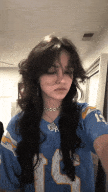 a girl with long hair is wearing a number 15 jersey