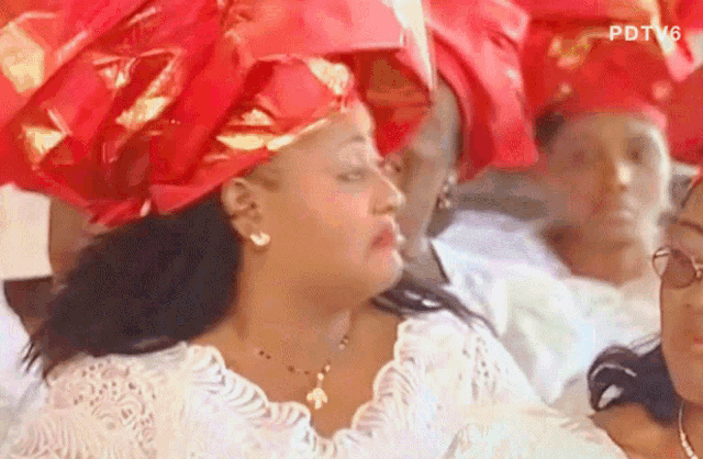 a woman wearing a red head scarf with the letters pdtv6 on the bottom left