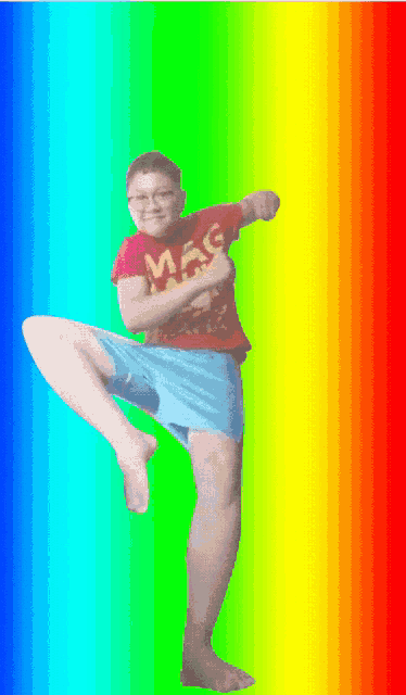 a boy wearing a red shirt that says mac is kicking in front of a rainbow background