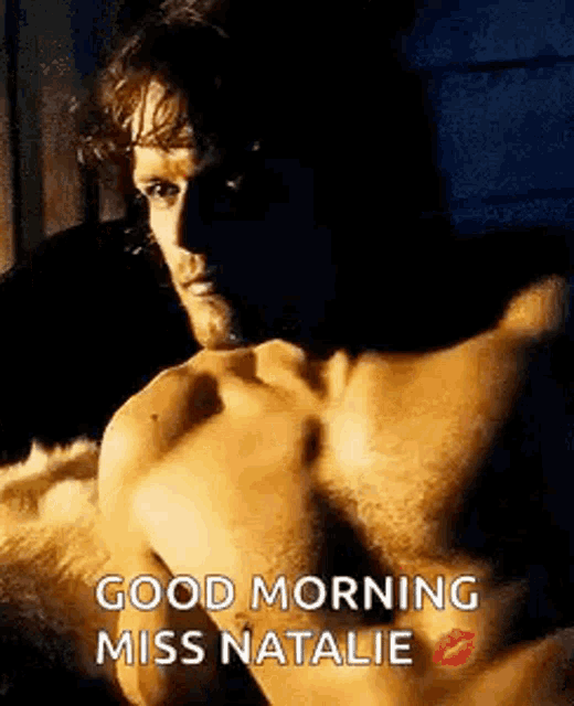 a shirtless man is laying on a bed with a kiss on his lips .