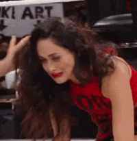 a woman in a red shirt is being touched by a man .
