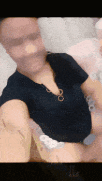 a man in a black shirt is taking a selfie with the letter l in the corner