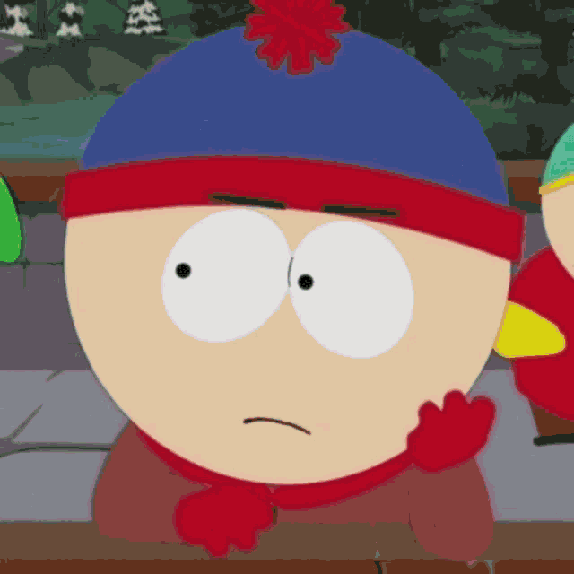 stanley from south park is wearing a blue hat and scarf and making a funny face .