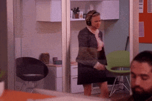 a woman wearing headphones is standing next to a chair