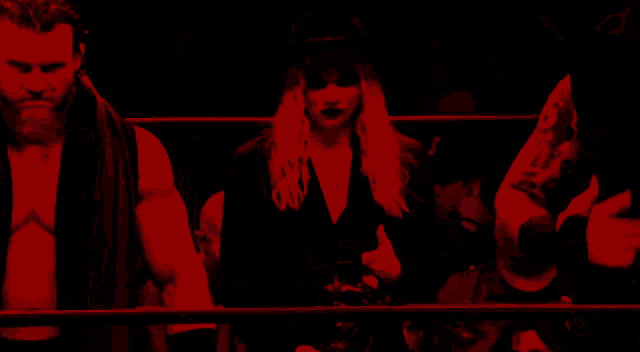 a man and a woman are standing in a dark room with red lights