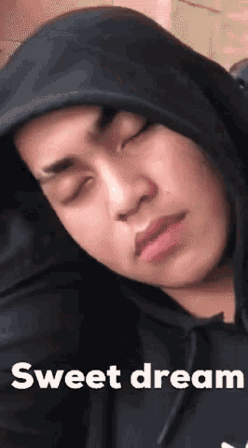 a man wearing a black hoodie is sleeping with the words sweet dream written below him