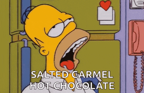 homer simpson is eating salted carmel hot chocolate from a refrigerator .