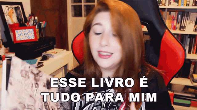a woman sitting in a red chair with the words esse livro e tudo para mim