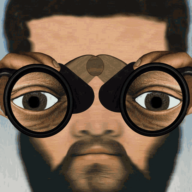 a man with a beard is looking through binoculars with his eyes visible