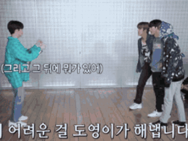 a group of people standing on a wooden floor with korean writing on the bottom