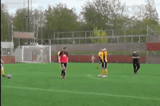a group of soccer players are playing on a field and one of them is wearing a red jersey with the number 8