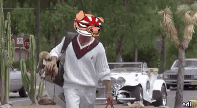 a man with a pig mask on his head is walking down the street with a dog .