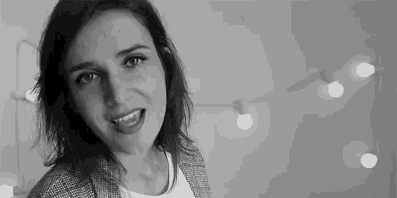 a woman is smiling in a black and white photo .