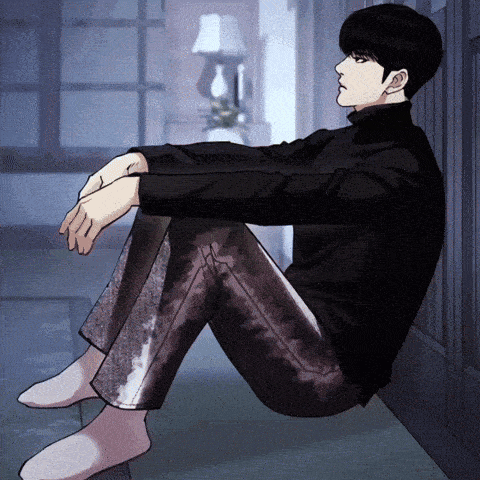 a man in a black turtleneck sits on the floor with his legs crossed