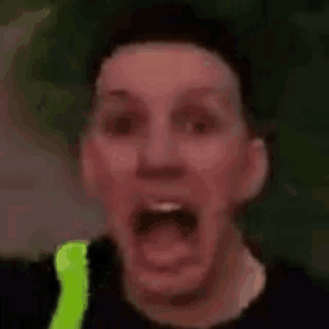 a close up of a man making a funny face with his mouth wide open .