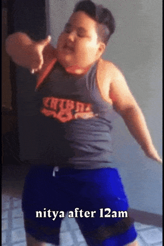 a fat boy in a tank top and blue shorts is dancing with the words nitya after 12am below him