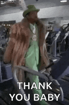 a man in a fur coat and green suit is walking on a treadmill in a gym and saying `` thank you baby '' .