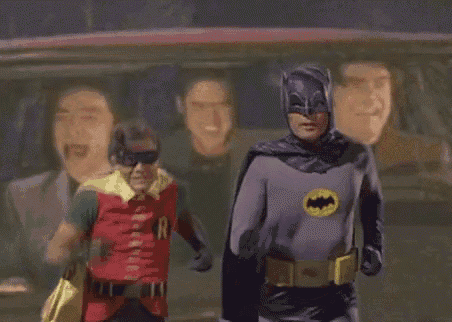 a man in a batman costume and a man in a robin costume are standing next to each other .