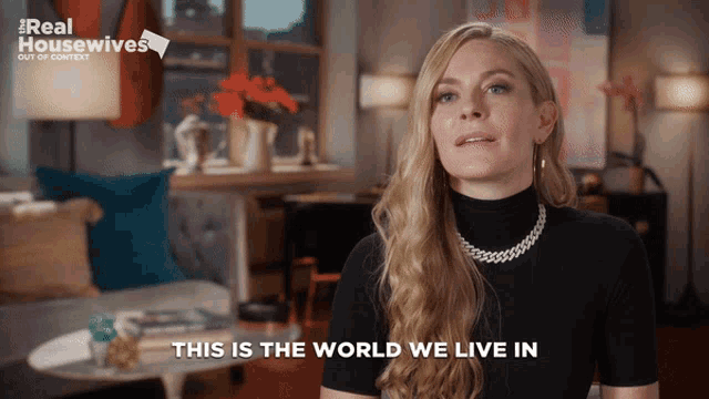 a woman says " this is the world we live in " in front of a real housewives ad