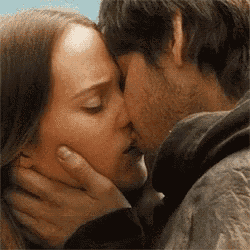 a man and a woman are kissing in a close up .