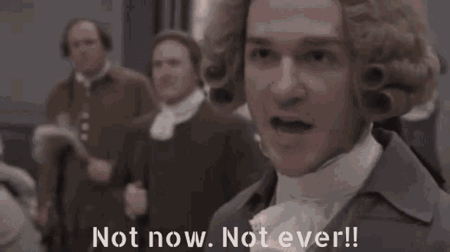 a group of men are standing in a room with the words `` not now , not ever '' written on the bottom .