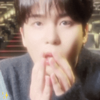 a close up of a person covering their mouth with their hand