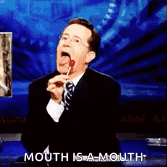a man in a suit and tie is licking a lollipop and saying " mouth is a mouth " .
