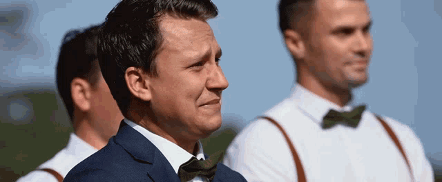 a man in a suit and bow tie is looking at something