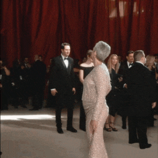 a man in a tuxedo is standing next to a woman in a dress