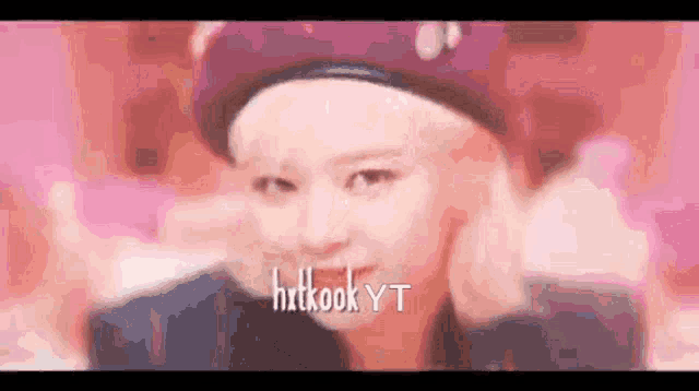 a blurry picture of a woman wearing a beret with the name hxtkook yt written on the bottom