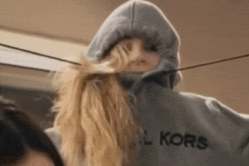 a woman wearing a michael kors hoodie is standing next to another woman