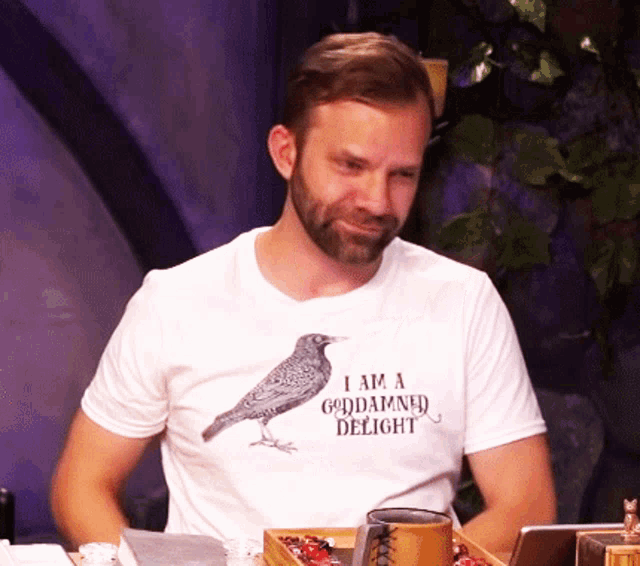 a man wearing a white t-shirt that says i am a goddamned delight